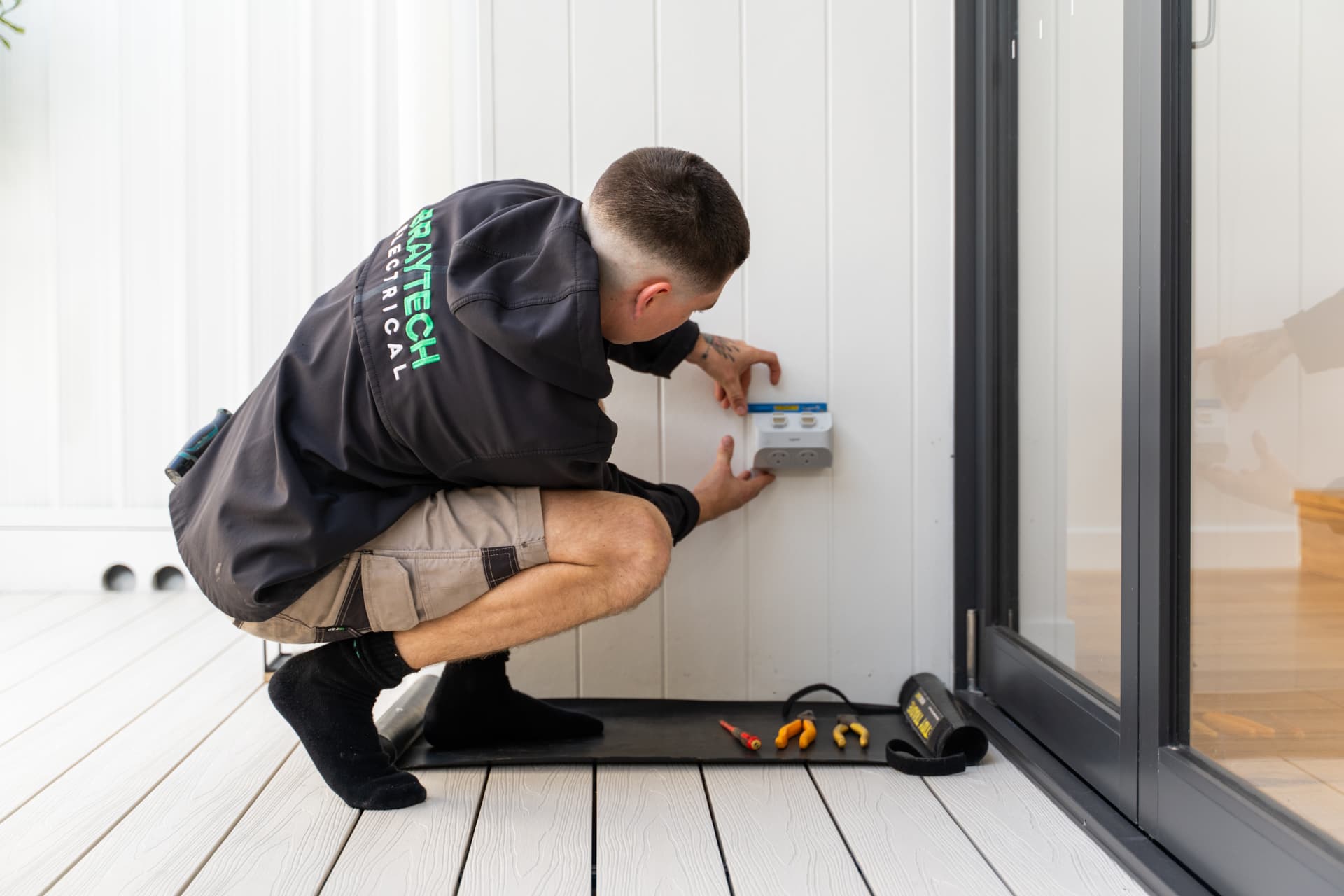 Braytech electrician installing an outdoor power outlet