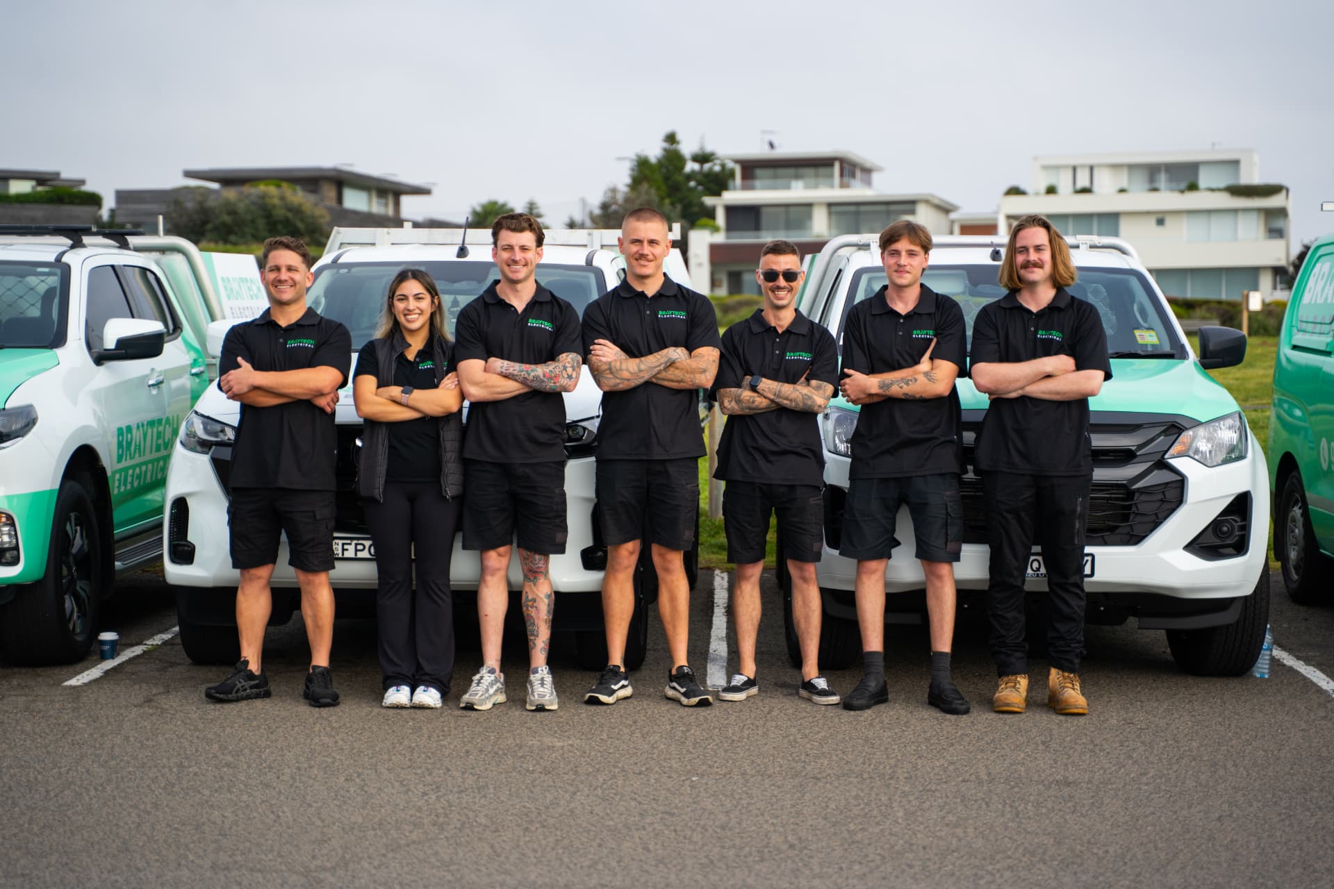 The Braytech Electrical team standing in front of their branded work vehicles